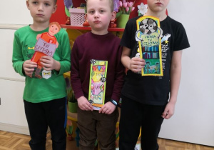 Chłopcy prezentują prace na konkurs plastyczny "Zakładka do książki".