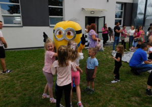 Dziewczynki przytulają się do Minionka i robią zdjęcia pamiątkowe.