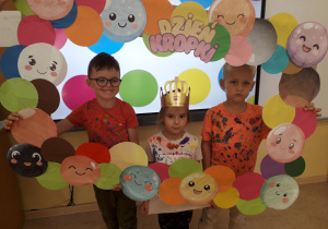 Grupa przedszkolaków pozuje do zdjęć w kropkowej fotobudce.