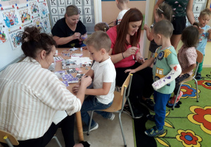 Rodzice ozdabiają dłonie dzieci tatuażami.