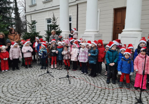 Dzieci stoją przed Pałacem w Starym Gostkowie i śpiewają piosenkę