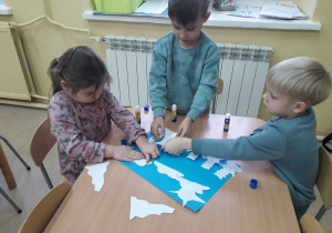 Dzieci tworzą zimowy pejzaż.
