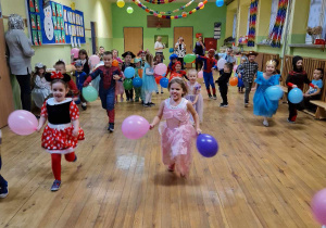 Dzieci w czasie biegu z balonami na holu przedszkolnym.