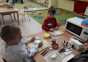 Chłopcy przy stoliku tworzą swoje mydełka.