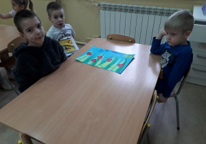 Chłopcy przy stoliku prezentują łąkę Biedronki Piatki.