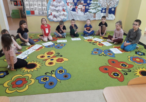 Przedszkolaki prezentują rysunki na temat trzech bezpiecznych zasad.