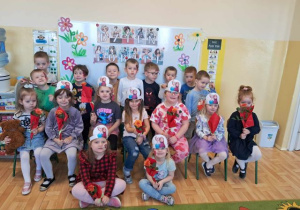Grupa młodsza pozuje do zdjęcia. Dziewczynki trzymają kwiatki.