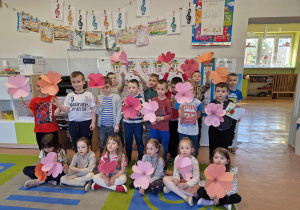 Dzieci z gr 5-6 latków pozują w grupie z kwiatami z papieru