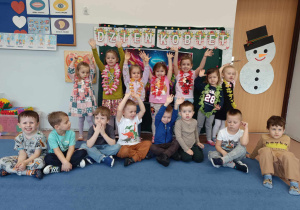 Dzieci z gr 3-4 latków pozują w grupie na tle dekoracji