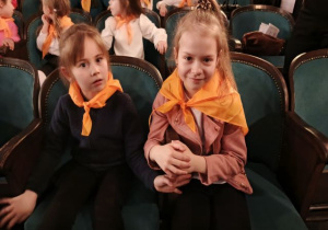 Dziewczynki w teatrze czekają na przedstawienie.
