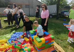 Chłopiec z rodzicami podczas zabawy dużymi klockami.