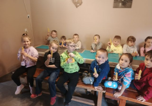 Przedszkolaki prezentują wykonane świece.