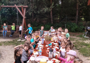 Dzieci przy stole w czasie poczęstunku