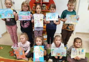 Przedszkolaki prezentują prace plastyczne na konkurs.