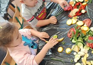 Dzieci układają kompozycje z pokrojonych warzyw