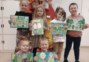 Przedszkolaki prezentują prace na konkurs "Portret Strażaka i Leśnika".