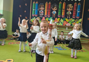 Chłopiec pozuje do zdjęcia z ołówkiem i dyplomem.