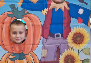 Dzieci w fotobudce z dyniami.