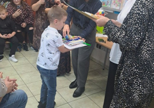 Chłopiec przyjmuje nagrodę za udział w konkursie.