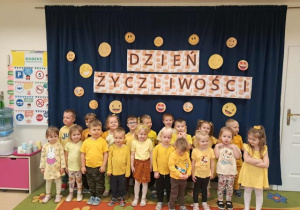 Dzieci z grupy 3,4-latków ubrane na żółto pozują do zdjęcia grupowego.