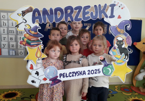 Dzieci pozują do zdjęcia w andrzejkowej fotobudce.