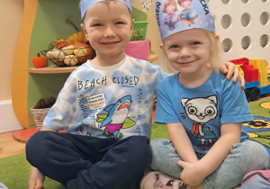 Chłopiec z dziewczynką pozują do zdjęciach, na głowie mają tematyczne niebieskie opaski.