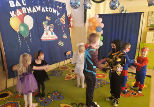 Dzieci w strojach karnawałowych podczas tańca.