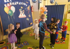 Dzieci w strojach karnawałowych podczas tańca.
