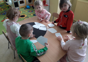 Dzieci przy stoliku podczas zabawy "Matematyczne igloo".