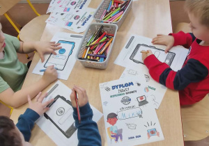 Dzieci kolorują karty pracy