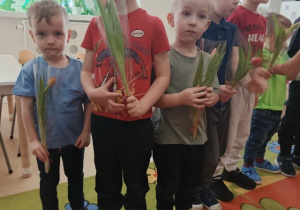 Chłopcy trzymają kwiatki, które wręczą dziewczynkom.