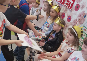 Chłopcy wręczają dziewczynom laurki