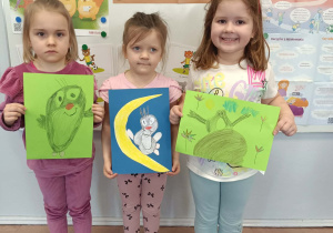 Dzieci stoją i prezentują prace na konkurs plastyczny