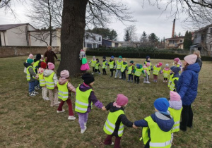 Przedszkolaki stoją dookoła marzanny i śpiewają piosenki na powitanie wiosny.