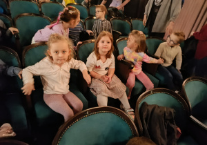 Dzieci siedzą w teatrze i czekają na przedstawienie