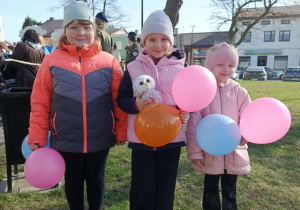 Dziewczynki z balonami podczas marszu ulicami Poddębic.
