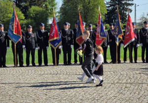 Przedszkolaki maszerują z kwiatami pod Obelisk.