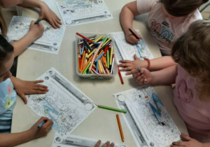 Dzieci siedzą przy stoliku i wykonują zadanie "Kubusiwego przyjaciela natury".