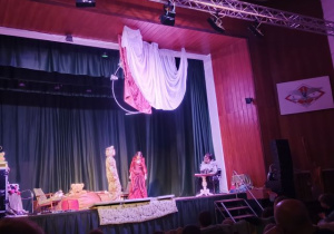 Dzieci z kółka teatralnego wraz z panią na scenie odgrywają swoje role.