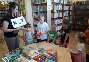 Dzieci w bibliotece poszukują zaginionych liter.