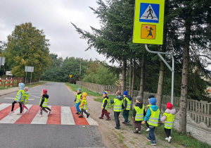 Dzieci przechodzą przez ulicę na przejściu dla pieszych