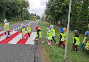 Dzieci przechodzą przez ulicę na przejściu dla pieszych
