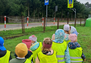 Dzieci oglądają znaki drogowe przy przedszkolu