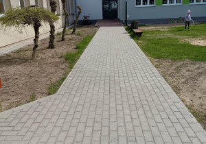 Chodnik przed wejściem do przedszkola wykonany z kostki betonowej.