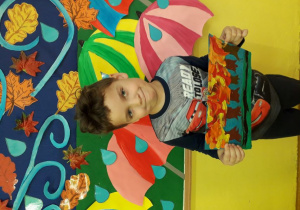 Chłopiec prezentuje pracę plastyczną, która zajęła III pozycję w konkursie.
