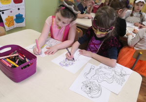 Dzieci kolorujące obrazki z bajkowymi postaciami