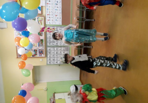 Tańczące dzieci w kostiumach karnawałowych na balu.