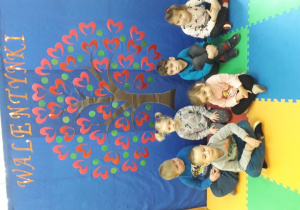 Grupa dzieci na tle dekoracji walentynkowej.