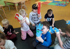 Dzieci bawią się pacynkami wykonanymi z gumowej rękawiczki.