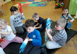 Dzieci bawią się pacynkami wykonanymi z gumowej rękawiczki.